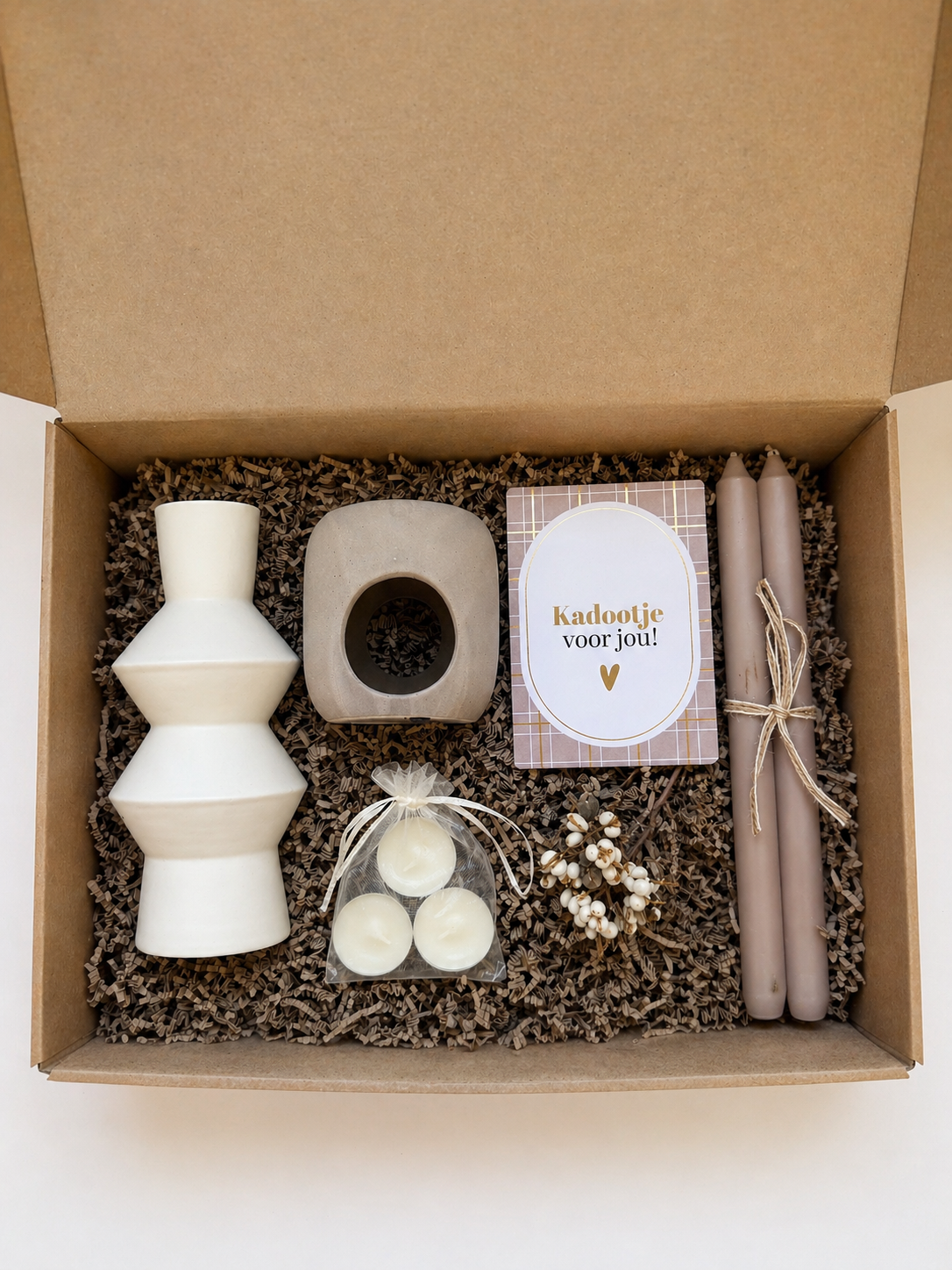 Cadeaupakket met een witte vaas, geurbrander, waxinelichtjes, dinerkaarsen en wenskaartje